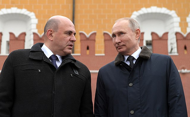Photograph of Mikhail Mishustin and Vladimir Putin standing
     next to each other.
